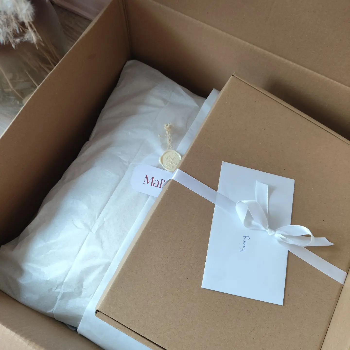 Photo d’un colis préparé par Mallyana Création, emballé avec soin et délicatesse – présentation soignée d’une création artisanale.