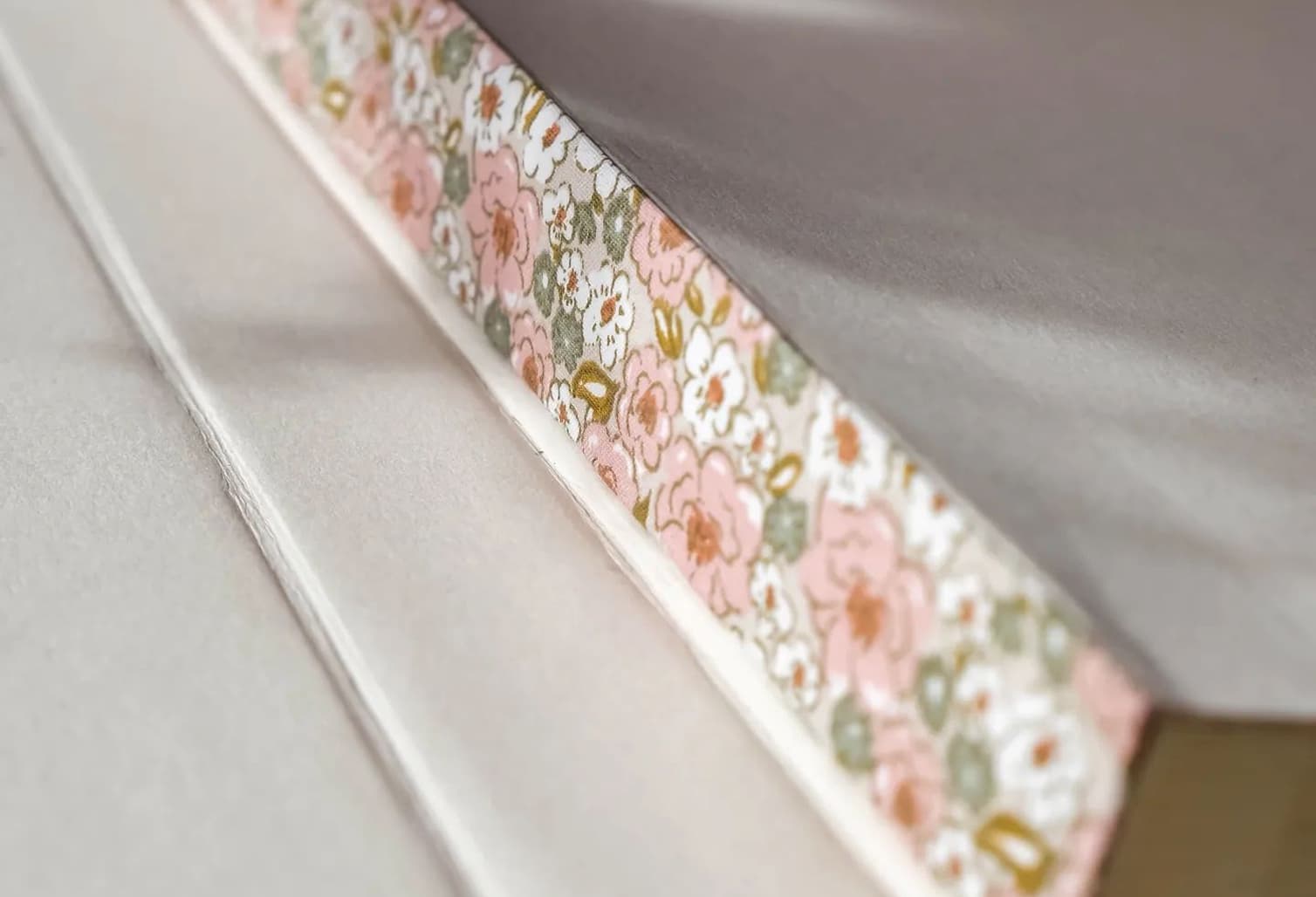 Gros plan détaillé sur une aiguille à coudre insérée dans un tissu, symbolisant le savoir-faire artisanal de Mallyana Création